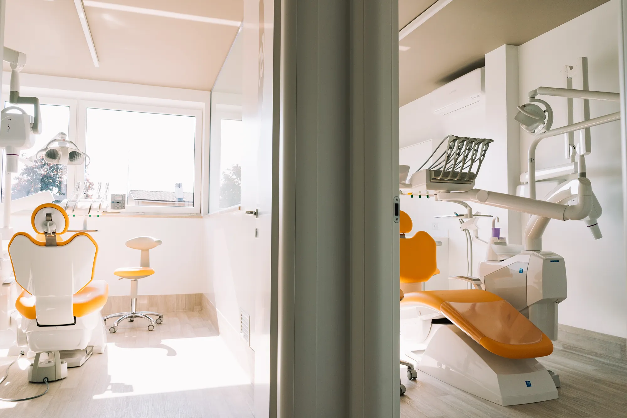 Due studi odontoiatrici con le poltrone arancioni, luminosi e ordinati